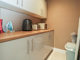 A laundry room with appliances on a countertop at Willow Cottage in Whiteparish