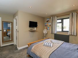 A bedroom with a bed and television at Willow Cottage in Whiteparish