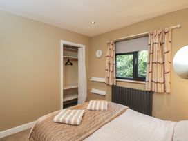 A bedroom with a bed and wardrobe at Willow Cottage in Whiteparish