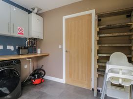 A utility room with a washing machine and a high chair at Willow Cottage in Whiteparish