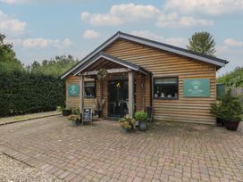 An outdoor view of a wooden building with a sign at Willow Cottage in Whiteparish