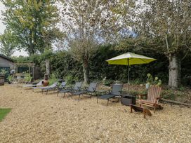 A garden with lounge chairs and an umbrella at Willow Cottage Whiteparish