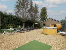 A garden area with lounge chairs and a barrel at Willow Cottage in Whiteparish