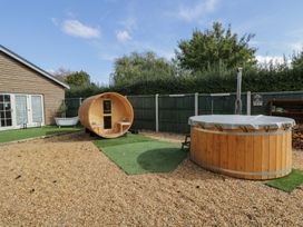 A garden with a barrel sauna and hot tub at Willow Cottage in Whiteparish