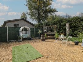 A garden with a bench, table and chairs at Willow Cottage in Whiteparish