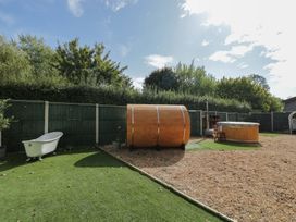 A garden with a bathtub and wooden barrel sauna at Willow Cottage in Whiteparish