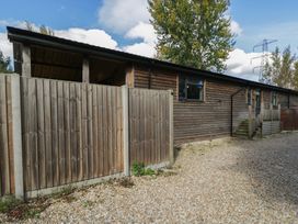 A wooden fenced area with a gravel driveway at Willow Cottage Whiteparish