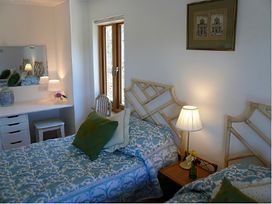 A bedroom with two beds and a desk at Cottage 2