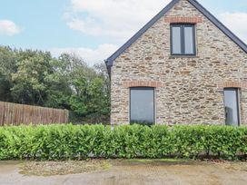 A house with windows and a hedge in front at Barn 2