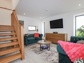 A living room with a staircase, couch and coffee table at Barn 2