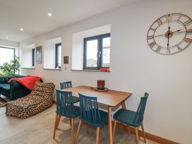 A living room with a dining table and a sofa at Barn 2 