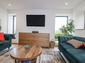 A living room with a coffee table and television at Barn 2