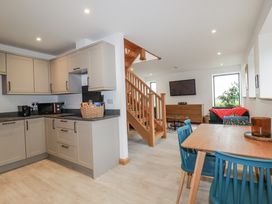 A kitchen and dining area with a staircase and living space at Barn 2 