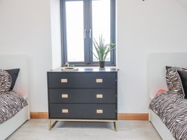 A bedroom with a dresser and beds at Barn 2