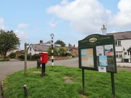 A street view with a post box and parish council sign at Milford in Wetheral