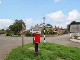 A street scene with a post box and signpost at Milford in Wetheral