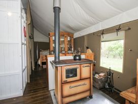 A kitchen with a stove and wooden furniture at Hedgerow in Bewdley