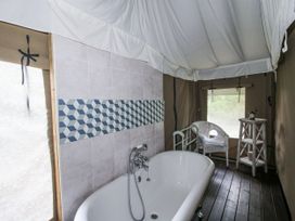 A bathroom with a bathtub and wooden table at Hedgerow in Bewdley