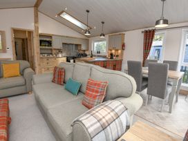 A living room with a sofa and dining area at Lakewood Retreat in Woodhall Spa