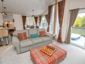 A living room with a sofa and chess board at Lakewood Retreat in Woodhall Spa