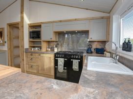 A kitchen with stove and sink at Lakewood Retreat in Woodhall Spa