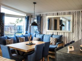 A living room with a sofa and dining table at Hotchkin Lodge in Woodhall Spa