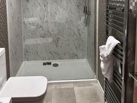 A bathroom with a shower and toilet at Hotchkin Lodge in Woodhall Spa