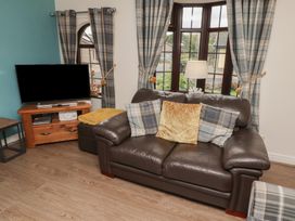 A living room with a sofa and television at Nobles Nook in Seahouses