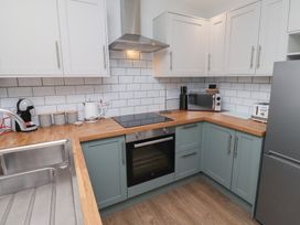 A kitchen with appliances and cabinets at Nobles Nook in Seahouses