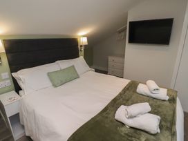 A bedroom with a bed, tv, and dresser at Nobles Nook in Seahouses