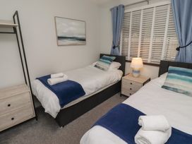 A bedroom with two beds and a nightstand at Nobles Nook in Seahouses