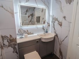 A sink and mirror in a bathroom at Nobles Nook in Seahouses