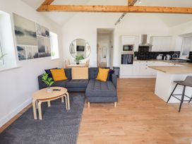 A living room with a sofa, coffee table, and dining area at Lodge 12 South Hykeham