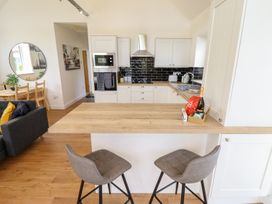 A kitchen with bar stools and a dining table at Lodge 12 in South Hykeham