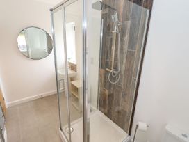 A bathroom with a shower, mirror, toilet, and sink at Lodge 12 South Hykeham