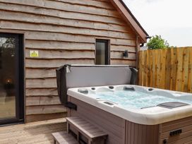 A hot tub on a wooden deck outside a building at Lodge 12 South Hykeham