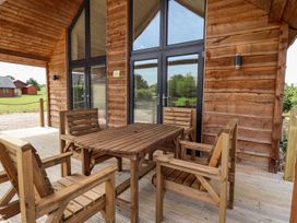 An outdoor seating area with a wooden table and chairs at Lodge 12 in South Hykeham