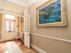 A hallway with a front door and stained glass windows at The Mount in Chippenham