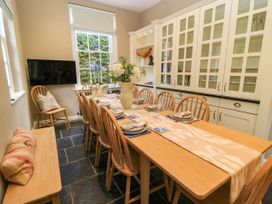 A dining room with a long table and chairs at The Mount in Chippenham