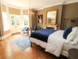 A bedroom with a bed and an armchair at The Mount in Chippenham