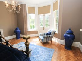 A sitting room with a chair and blue decor at The Mount in Chippenham