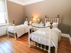 A bedroom with two beds and a dresser at The Mount in Chippenham