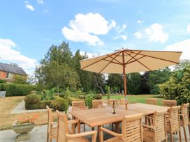 An outdoor dining area with a table and chairs under an umbrella at The Mount in Chippenham