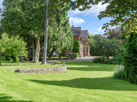 A garden with trees and a stone wall at The Mount Private Estate Upper Seagry