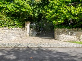 A gate with a stone wall and greenery at The Mount Private Estate Upper Seagry