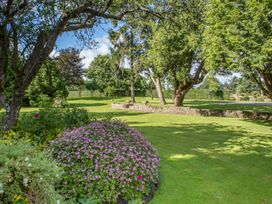 A garden with trees and a flower bed at The Mount Private Estate Upper Seagry