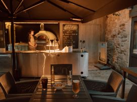 An outdoor seating area with a menu board and an oven at Askrigg in Aysgarth