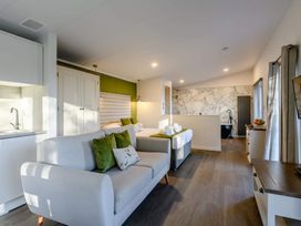 A living room with a sofa and kitchen area at Somersby (Pet) in Louth