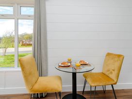 A dining area with a small table and two chairs at The Woodnewton in Wansford
