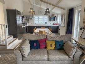 A kitchen with a dining table and sofa at The Cow Shed in Bishopswood